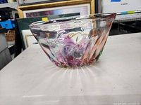 Side view showing colorful swirled glass with ridged design and flared lip.