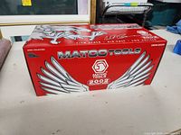Photo of red Matco Tools 2002 collector box with large silver eagle wings graphic and Matco Tools logo.