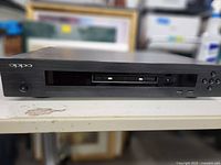 Front view of Oppo Blu-ray Disc Player showing disc tray missing faceplate and closed disc tray.