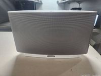 Front view of white Sonos speaker showing metal grille and Sonos logo