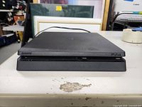 Front view showing console with disc drive slot and ports.