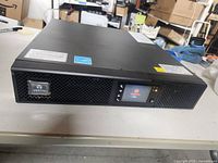 Front view of Vertiv UPS showing LCD display and logo on vented panel