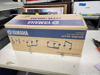 Original Yamaha HTR-5830 box with music note graphics and Yamaha branding.
