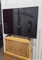 Front view of Toshiba 46-inch TV on wooden stand showing screen and stand.