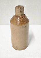 Front and side views of the antique Doulton of Lambeth stoneware ink bottle, showing the beige and brown glazed finish and rectangular neck opening.