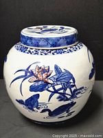 Side view of round Chinese blue and white porcelain ginger jar with detailed naturalistic designs of frogs, lily pads, lotus flowers, and birds