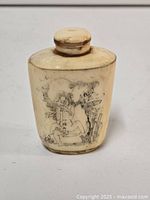 Front side of snuff bottle showing erotic scene drawn in black ink on ivory colored bottle.