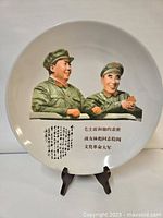 Front view of plate depicting Mao and Lin Biao, mounted on stand against white background