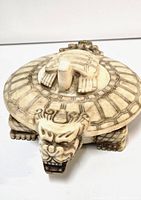 Front view of turtle with dragon head carved in detail, showing the top of the removable lid with smaller turtle on it.