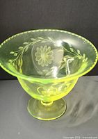 Front view of footed uranium glass bowl showing etched floral pattern and beaded rim