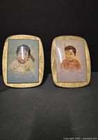 Two framed pastel portraits of Indigenous children by Dorothy Oxborough shown side by side on a dark background