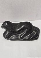 Dark gray soapstone seal sculpture shown front side view on white background.
