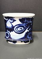Front view of the glazed porcelain vase showing the cobalt blue bird design on white background.