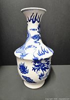 Front view of blue and white porcelain vase showing cobalt blue dragon and flame designs on white background