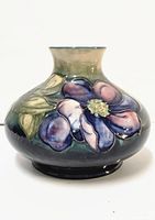 Front view of Moorcroft bulb vase showing pink and purple floral design with green leaves on bulbous body with gradient glaze.