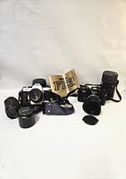 Overview of both camera bodies with lenses, straps, manual and lens container