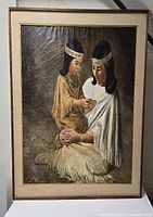 Frontal photo of the signed oil painting featuring a mother and daughter from the Nez Pearce Tribe. Frame, matting, and canvas visible with damage and craquelure.