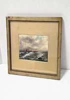 Framed watercolor showing entire artwork with stormy sea scene and beige matte inside a gold-toned frame with some wear and scuffing.