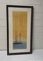 Full view of the framed lithograph showing sailboat masts with yellow and blue background.