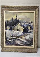 Full view of signed oil painting depicting rustic buildings in a snowy winter scene with a damaged ornate frame.