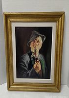 Frontal image of the framed oil painting depicting an older man with a pipe, highlighting overall condition and frame.
