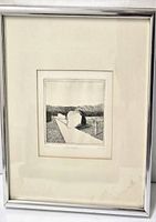 Framed black and white print featuring a minimalist landscape with a light path leading through darker terrain textures.