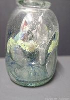 Front view of signed art glass vase with abstract color design and bubbles in glass
