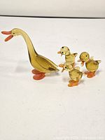 Front view of mother duck with three ducklings on white background