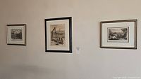 Three framed vintage black and white sketch prints hanging on wall, evenly spaced, central larger surrounded by two smaller