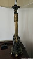 Tall solid metal gothic style lamp with a slender column and decorative gothic details near the base.