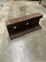 View of the anvil showing rusted railroad track steel with two holes through the base section