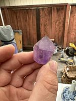 Close-up front view of the amethyst crystal showing pointed termination and natural facets.