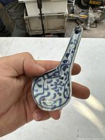 Oblique top view of the spoon showing blue floral patterns and spoon shape held in hand