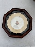 Full view of the antique porcelain plate framed in a dark wooden shadowbox with glass cover