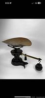 View showing full scale with iron base, curved arm with hanging weights, and large brass weighing pan