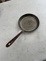 Full view of the antique pan showing interior and long iron handle.