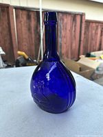 Front angled view of antique cobalt blue glass bottle with raised face of Jenny Lind
