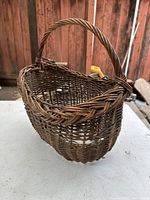 Front angled view showing the basket's overall shape and handle, with visible woven fibers and missing bottom area.