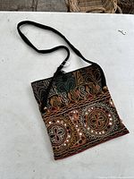 Front view of antique Tibetan embroidered purse showing detailed embroidery and glass bead inlays.