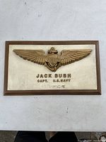 Full front view of the wooden plaque with brass eagle and engraved nameplate.