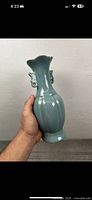 Front angled view showing vase held in hand, highlighting crackle glaze and double ear handles