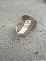 Image of the crystal prism showing the angled top and flat base on concrete surface.