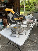 Full view of Dewalt miter saw on folding table in garage