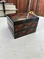 Side angle showing the bento box's three stackable tiers and floral exterior design.