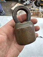 Large antique Segal padlock held in hand, showing full body and shackle with the brand mark.