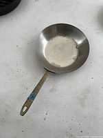 Photo showing top view of Paul Feuerring copper pan with interior marks and discoloration