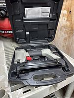 Porter Cable pneumatic nailer inside carrying case with manual in lid compartment