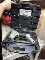 Porter Cable pneumatic finish nailer inside a black molded carrying case with instruction manual visible in the lid.