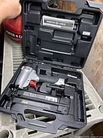 Porter Cable pneumatic nailer in black carrying case showing tool and case interior