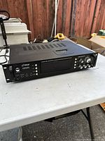 Front angled view of black Pyle P2002ABTI hybrid amplifier showing vents on top and front panel controls including power button, headphone ports, and screen.